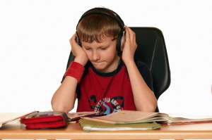A child is hearing music instead of doing his homework